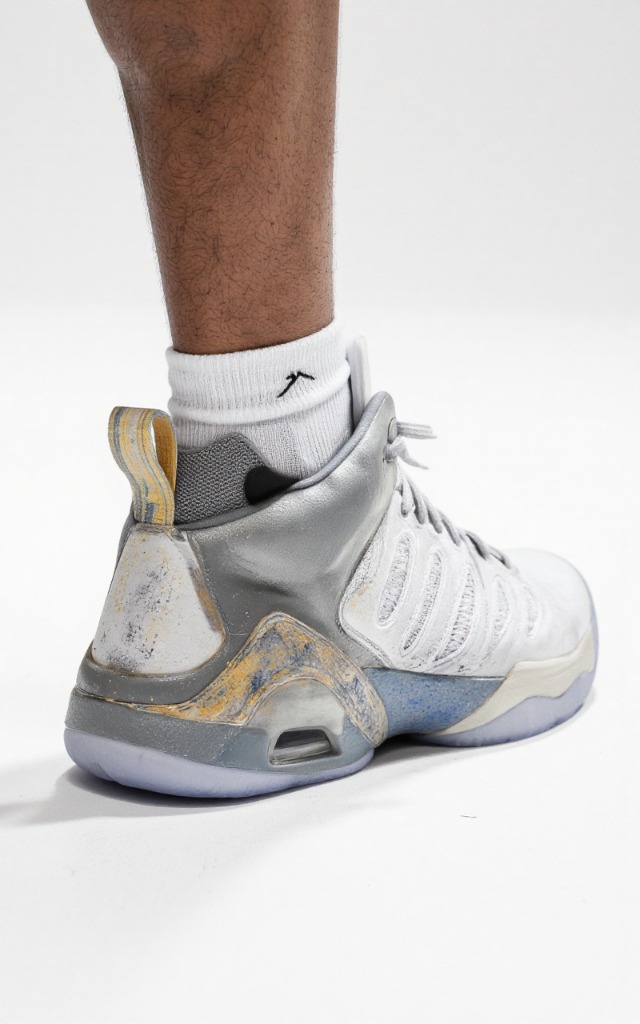 A male model wearing Basketball shoes, against a white background, with a close   up of the feet